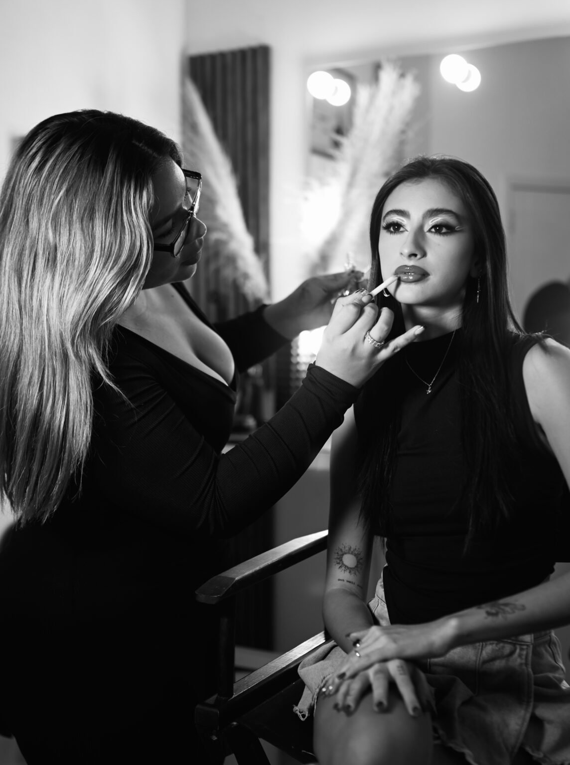 Maquillista profesional Kiara Paredes aplicando maquillaje de ojos a una modelo en su estudio